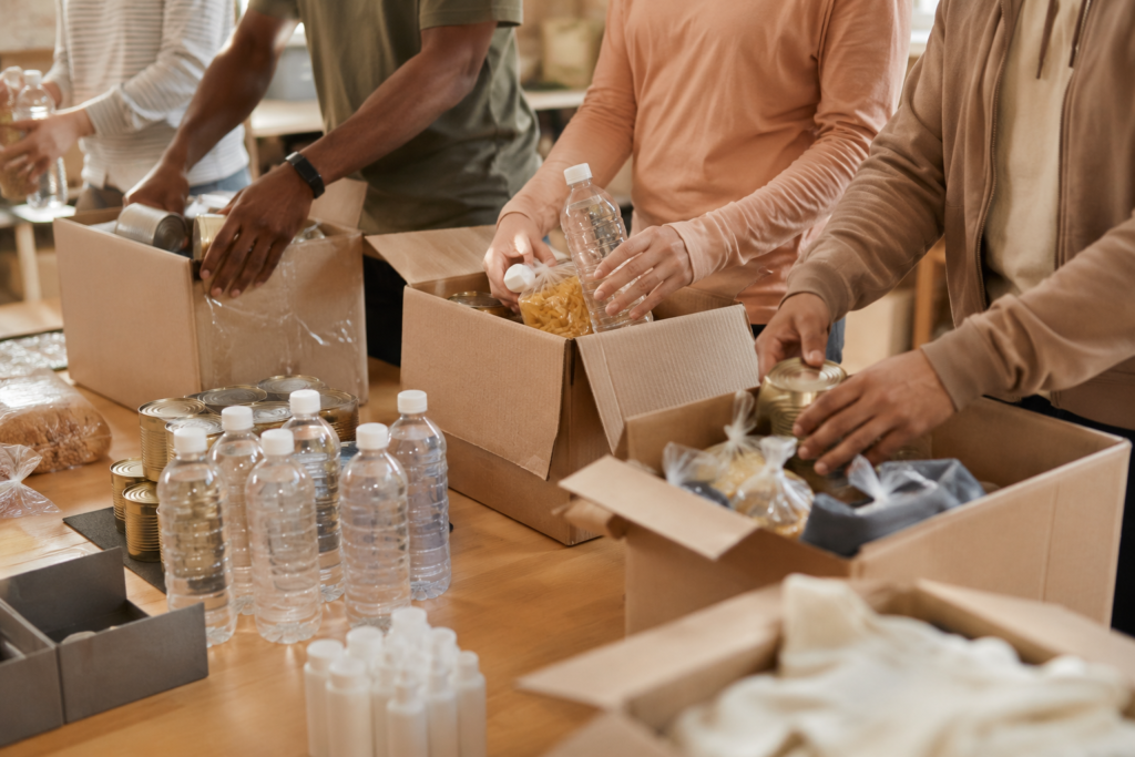Voluntarios empacan cajas con agua, alimentos no perecederos y artículos de higiene en un centro de acopio comunitario para apoyar a los afectados por el terremoto en Venezuela 2026.